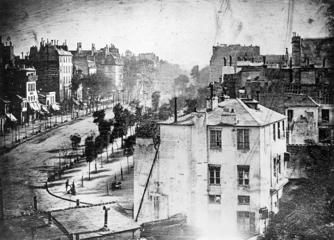 "Boulevard du Temple", taken by Daguerre in 1838 in Paris, includes the earliest known photograph of a person. The image shows a street, but because of the over ten minute exposure time the moving traffic does not appear. At the lower left, however, a man apparently having his boots polished, and the bootblack polishing them, were motionless enough for their images to be captured.